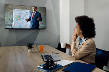 Black female entrepreneur listening online business seminar via conference call in the office.