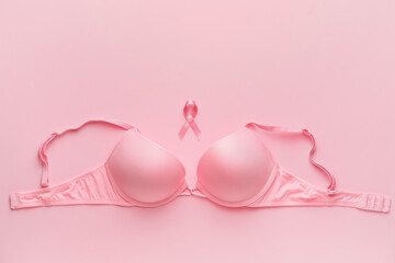Pink ribbon and bra on color background. Breast cancer awareness concept - obrazy, fototapety, plakaty