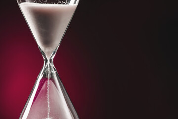 Hourglass on dark color background. Time management concept