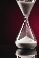 Hourglass on dark color background. Time management concept