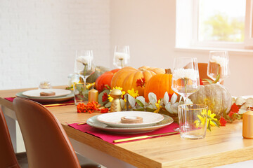 Beautiful table setting with pumpkins in dining room