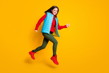 Fototapeta na wymiar Full size photo of cheerful girl jump run winter season discount want hurry wear blue green style sweater isolated over bright shine color background
