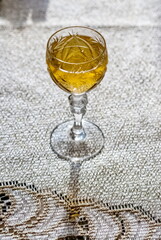 A glass of white wine close up on the background of the tablecloth on the table