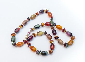 Purchased beads of colored stones close-up on a white background