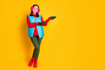Fototapeta na wymiar Full size photo of positive girl promoter point hands mittens copyspace display offer advert object wear pink sweater boots isolated over bright shine color background