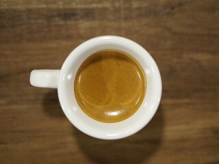 Top view of espresso coffee cup on wooden table background.