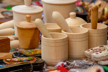 Obraz na płótnie Canvas A variety of wooden crafts for the kitchen. Mortar and pestle. Side view of a group of wooden mortar and pestle sold at a fair.