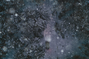 car in the evening forest in winter, top view, copter, aero photo, landscape winter forest