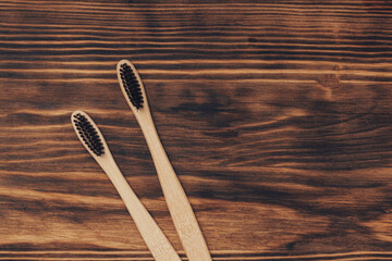 Two biodegradable wooden oral hygiene accessories on yellow background  . Zero waste, plastic free, sustainable lifestyle concept .close up