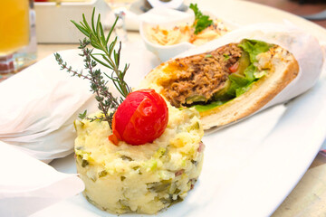 Delicious pulled pork sandwich with potato puree and coleslaw salad
