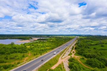 Fototapeta na wymiar Panorama of the Kirov city and Oktyabrsky district in the nord part of the city of Kirov on a summer day from above. highway across the bridge over the Vyatka river at the entrance to the city.