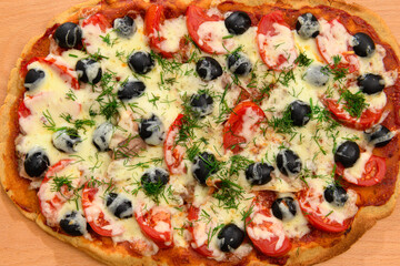 homemade pizza, vegetarian food, baked vegetables and cheese, tomatoes and olives, delicious food on a wooden background