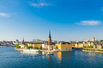 Fototapeta na wymiar Watercolor drawing of Aerial panoramic top view of Riddarholmen district with Riddarholm Church and typical sweden gothic buildings, boat ship sailing on water of Lake Malaren in Stockholm, Sweden