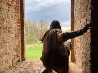 girl in the window of an abandoned building