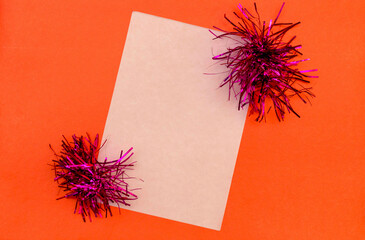 white sheet of paper decorated with tinsel on a red background.