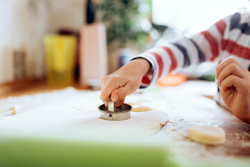 Happy boy preparing a scone in the kitchen