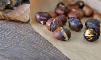 close on roasted chestnuts  on paper on a plank