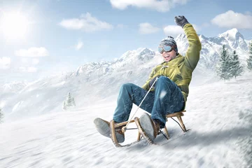 Fotobehang Happy man riding on a sled in winter © photoschmidt