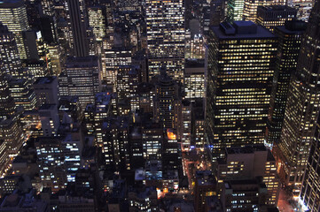 Fototapeta na wymiar New york city lights of business offices in Manhattan at dusk or dawn. Urban cityscape at twilight. Concept of overpopulated megapolis. USA/America. Home office concept during coronavirus. 