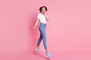 Full length body size profile side view of nice amazed slender skinny cheerful girl jumping going isolated over pink pastel color background