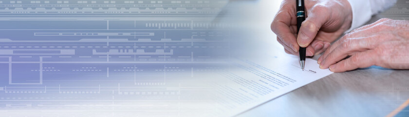 Hand of businessman signing a document; panoramic banner