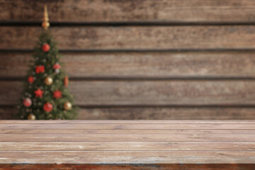 Empty wooden desk with christmas tree in background. Background for product presentation