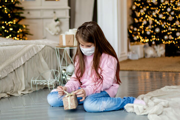 A little girl in a mask uncovers a gift.