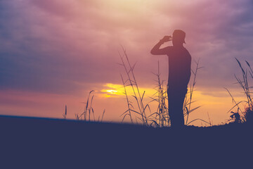 silhouette of man standing on  mountain at sunset or sunrise time. success .