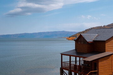 Cozy house near mountain lake in autumn. Countryside landscape. Autumn rural landscape. Markakol lake, Kazakhstan. Tourism in Kazakhstan concept. Beautiful fall nature.