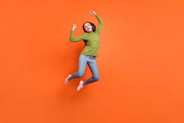 Fototapeta na wymiar Full body photo of young excited girl celebrate win victory goal fists hands jump isolated over orange color background