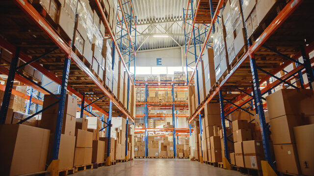 Big Retail Warehouse full of Shelves with Goods in Cardboard Boxes and Packages. Logistics, Sorting and Distribution Facility for Product Delivery.