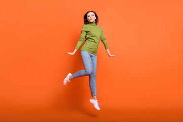 Fototapeta na wymiar Full size photo of young attractive girl happy positive send air kiss have fun jump isolated over orange color background