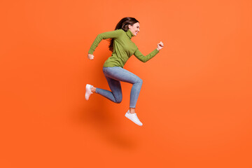 Fototapeta na wymiar Full body profile side photo of young crazy girl jump run wear denim look empty space isolated over orange color background
