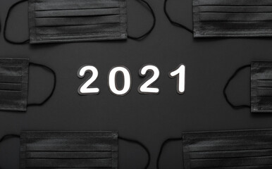 2021 text lettering in Black medical face mask pattern frame. Protective face surgical masks. New Year 2021 in quarantine covid 19 Coronavirus Lockdown