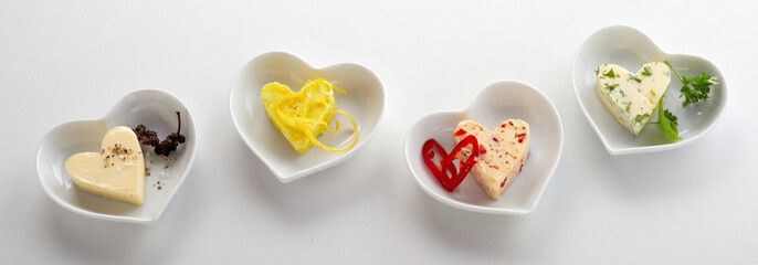 Four heart shaped bowls with savory butter pats