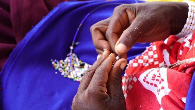 Making of handmade jewellery. Masai african women hands, top view, close up. Island of Zanzibar, Tanzania, East Africa