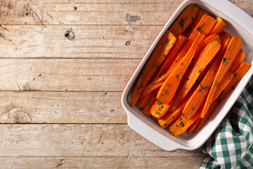 Honey glazed carrots on wooden table.Top view.Copy space	