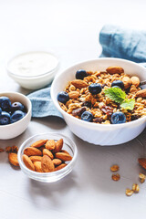 Baked granola with yogurt and blueberries on a gray table.