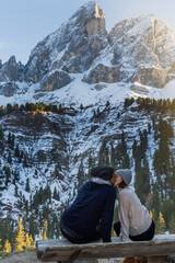 A couple giving each other a kiss and in the background the mountains.