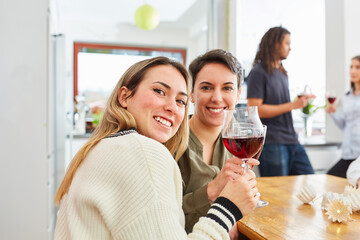 Zwei Frauen als Freundinnen stoßen auf Feier mit Rotwein an