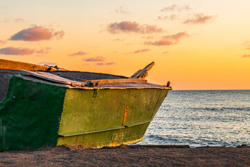 Sunset and a small boat on the beach of the Black Sea in Anaklia, Georgia, Samegrelo-Zemo Svaneti.
