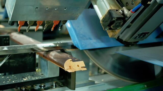 Manufacturing doors. Modern industrial equipment for making furniture. Machine tool cutting wooden board. Close-up.