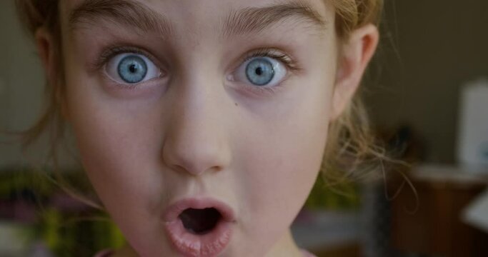 Child Girl Looks and Is Surprised Happy to Receive Surprise. Portrait Little Kid With Blue Eyes Looking at Camera Closeup. Surprised Girl Face. Close up of Shocked Child Face Expression. Wow Emotion.