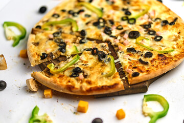 Tasty appetizing classic italian traditional pizza with cheese, olives, fresh vegetables and ham