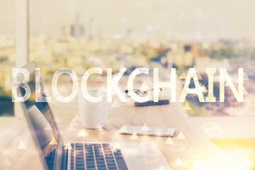 Double exposure of blockchain theme hologram and table with computer background. Concept of bitcoin crypto currency.