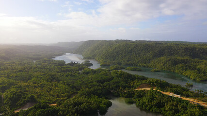 A rainforest with a river among green hills and mountains, aerial view . Philippines, Mindanao.