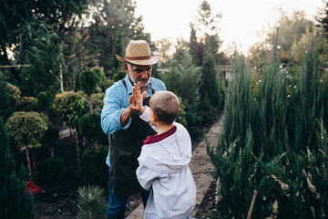 little boy with his grandfather in family tree nursery