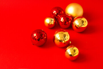 Set of red and golden Christmas balls on red background. Merry Christmas card. Concept of celebrating new year. Copy space