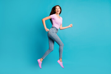 Fototapeta na wymiar Full length profile photo of funky pretty girl jump run open mouth wear pink t-shirt footwear jeans isolated blue color background
