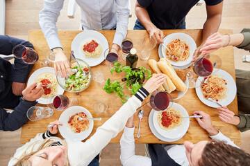 Freunde genießen gemeinsame Pasta Mahlzeit von oben